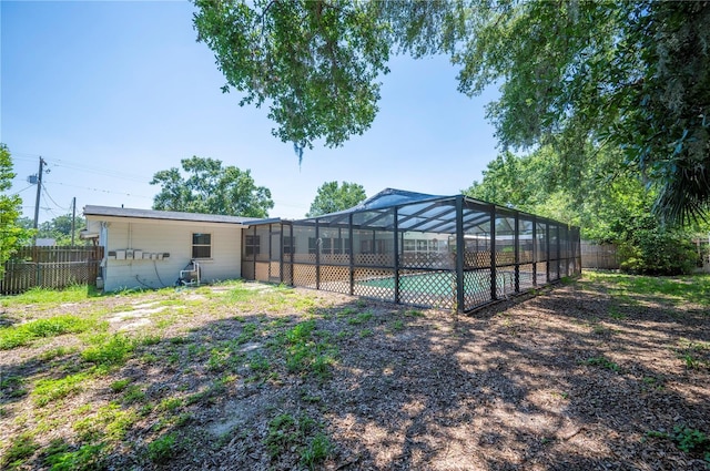 961 Oleander Dr SE, Winter Haven, FL 33880 - rear view of house with a fenced backyard and glass enclosure