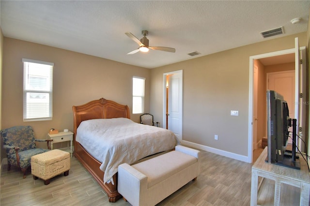 1100 Sugarwood St, Davenport, FL 33837 - bedroom featuring light wood-style flooring, baseboards, ceiling fan, and a textured ceiling