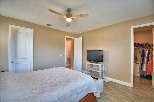 1100 Sugarwood St, Davenport, FL 33837 - bedroom with baseboards, light wood finished floors, a closet, a spacious closet, and ceiling fan