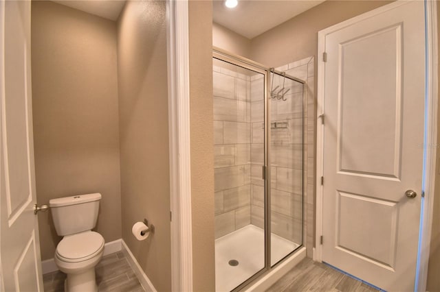 1100 Sugarwood St, Davenport, FL 33837 - full bathroom with a shower stall, wood finished floors, toilet, and baseboards