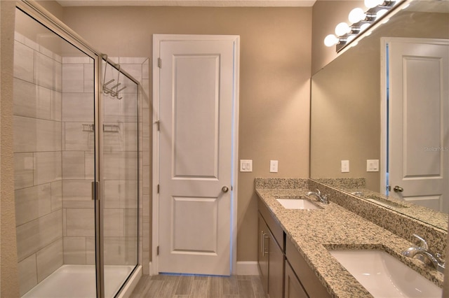 1100 Sugarwood St, Davenport, FL 33837 - full bathroom with a stall shower, double vanity, wood finished floors, and baseboards