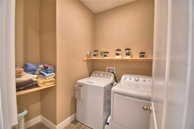 1100 Sugarwood St, Davenport, FL 33837 - laundry area with washing machine and dryer, wood finished floors, and baseboards