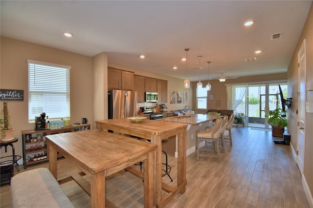 1100 Sugarwood St, Davenport, FL 33837 - kitchen featuring appliances with stainless steel finishes, a sink, light wood-type flooring, recessed lighting, and baseboards