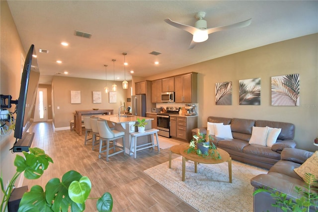 1100 Sugarwood St, Davenport, FL 33837 - living area with light wood-style flooring, recessed lighting, a ceiling fan, and baseboards