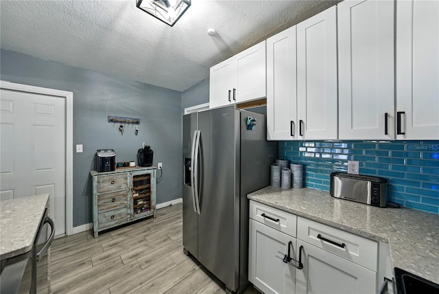 1140 W Seminole Trl, Bartow, FL 33830 - kitchen with stainless steel fridge, decorative backsplash, light wood-style floors, a textured ceiling, and white cabinetry