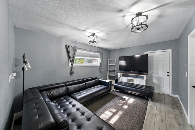 1140 W Seminole Trl, Bartow, FL 33830 - living area featuring a chandelier, light wood-type flooring, baseboards, and a textured ceiling