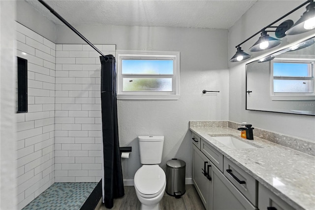 1140 W Seminole Trl, Bartow, FL 33830 - bathroom with a textured ceiling, vanity, toilet, a tile shower, and wood finished floors