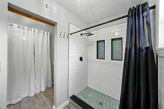 1140 W Seminole Trl, Bartow, FL 33830 - bathroom featuring wood finished floors, a tile shower, and a textured ceiling