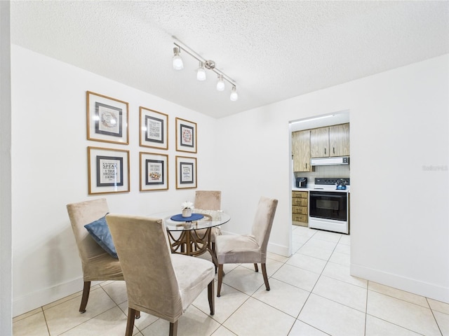 2700 Bayshore Blvd Unit 3210, Dunedin, FL 34698 - dining area featuring light tile patterned floors, baseboards, a textured ceiling, and rail lighting