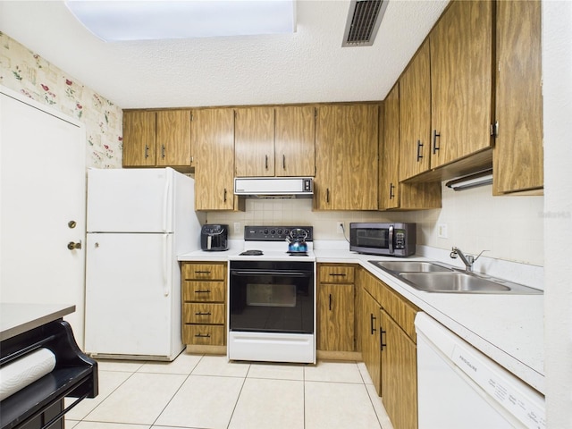 2700 Bayshore Blvd Unit 3210, Dunedin, FL 34698 - kitchen featuring white appliances, ventilation hood, brown cabinetry, light countertops, and a sink