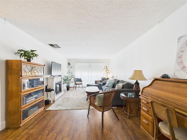 2700 Bayshore Blvd Unit 3210, Dunedin, FL 34698 - living room with a glass covered fireplace, a textured ceiling, and dark wood-style flooring