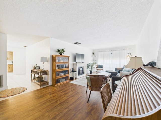 2700 Bayshore Blvd Unit 3210, Dunedin, FL 34698 - living area with a glass covered fireplace, wood finished floors, and a textured ceiling