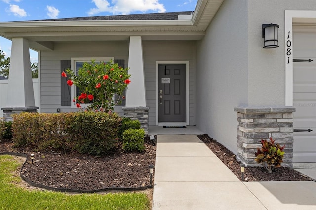 1081 Sandpiper Loop, Winter Haven, FL 33881 - property entrance featuring covered porch, stucco siding, and stone siding