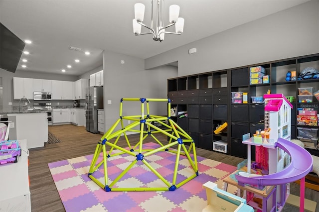 1081 Sandpiper Loop, Winter Haven, FL 33881 - playroom featuring wood finished floors, recessed lighting, a chandelier, and a sink