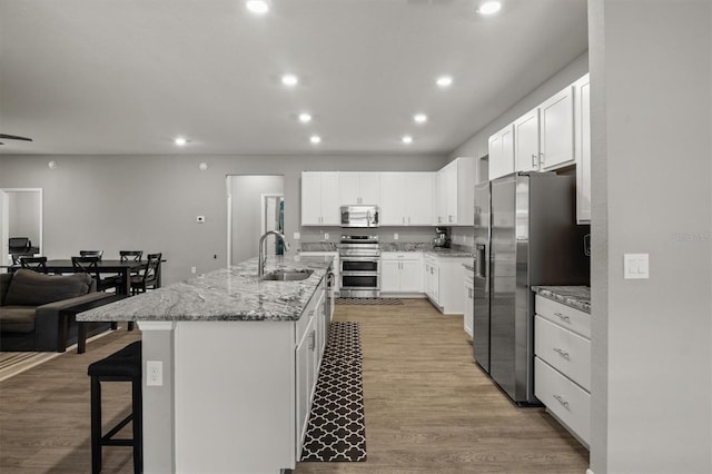 1081 Sandpiper Loop, Winter Haven, FL 33881 - kitchen featuring appliances with stainless steel finishes, a sink, recessed lighting, an island with sink, and a breakfast bar area