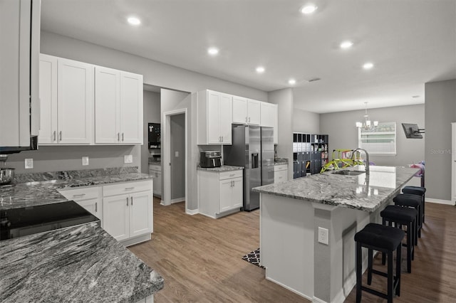 1081 Sandpiper Loop, Winter Haven, FL 33881 - kitchen with stainless steel refrigerator with ice dispenser, a breakfast bar, white cabinetry, and recessed lighting