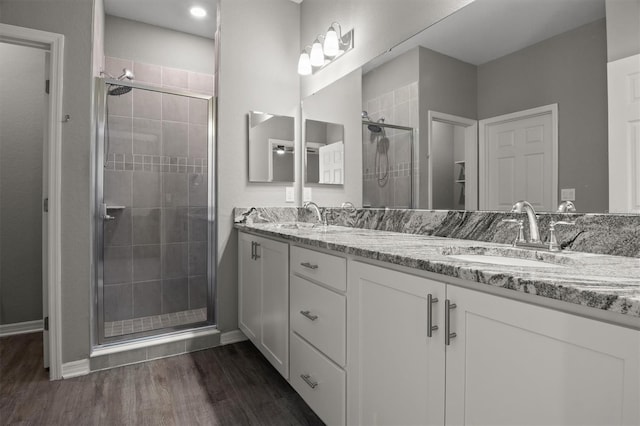 1081 Sandpiper Loop, Winter Haven, FL 33881 - full bathroom featuring a shower stall, double vanity, wood finished floors, and baseboards