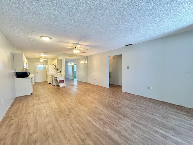 254 Winter Ridge Blvd Unit 254, Winter Haven, FL 33881 - unfurnished living room featuring a ceiling fan, light wood finished floors, and a textured ceiling