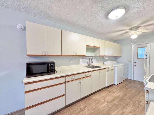 254 Winter Ridge Blvd Unit 254, Winter Haven, FL 33881 - kitchen featuring a sink, white appliances, a textured ceiling, washer and dryer, and light countertops