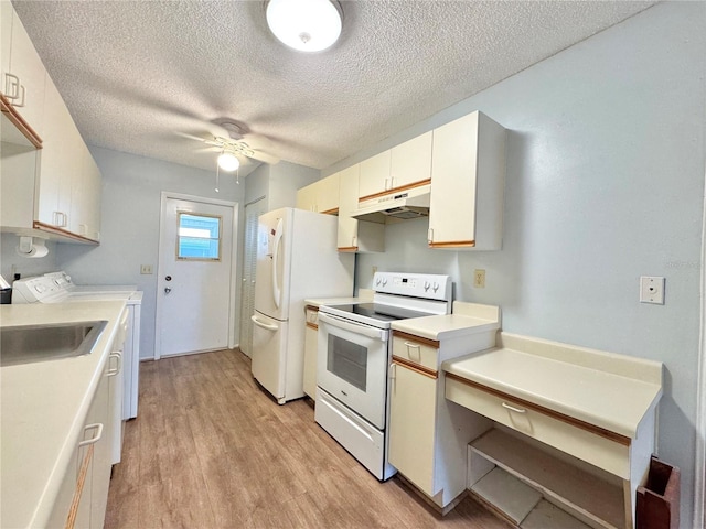 254 Winter Ridge Blvd Unit 254, Winter Haven, FL 33881 - kitchen with white appliances, washer and dryer, under cabinet range hood, a textured ceiling, and light wood-style flooring