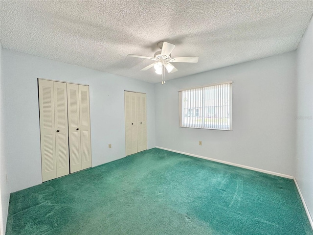 254 Winter Ridge Blvd Unit 254, Winter Haven, FL 33881 - unfurnished bedroom featuring two closets, carpet floors, a ceiling fan, baseboards, and a textured ceiling