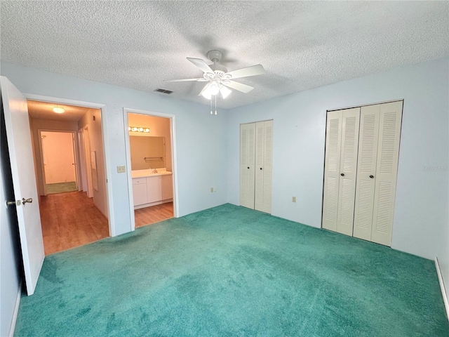 254 Winter Ridge Blvd Unit 254, Winter Haven, FL 33881 - unfurnished bedroom with carpet flooring, two closets, a textured ceiling, a ceiling fan, and ensuite bath
