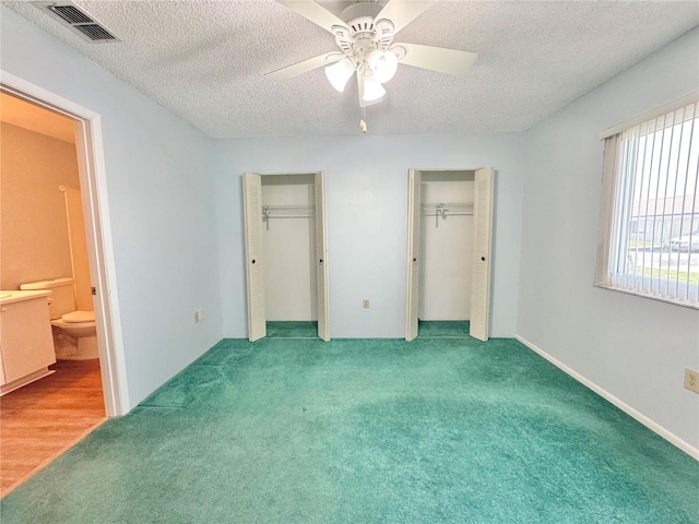 254 Winter Ridge Blvd Unit 254, Winter Haven, FL 33881 - unfurnished bedroom with multiple closets, a textured ceiling, carpet floors, ensuite bath, and a ceiling fan