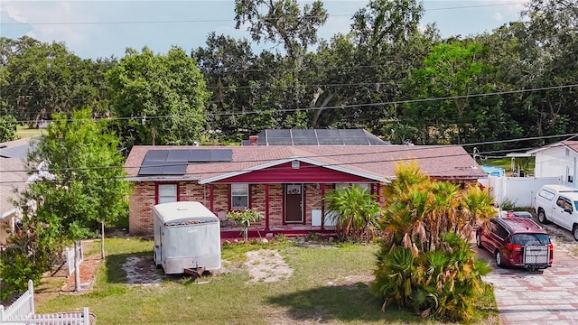 2213 W Pilaklakaha Ave, Auburndale, FL 33823 - view of front of house featuring solar panels, brick siding, and roof with shingles
