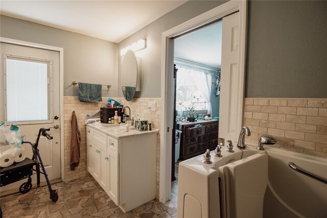 2213 W Pilaklakaha Ave, Auburndale, FL 33823 - full bath with tile walls, a bath, wainscoting, and vanity