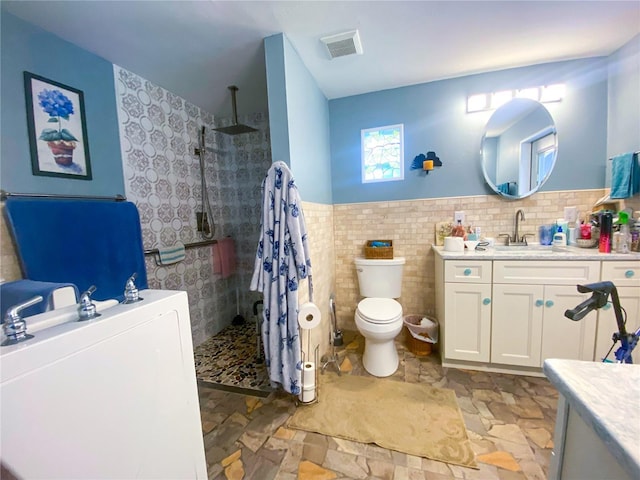 2213 W Pilaklakaha Ave, Auburndale, FL 33823 - bathroom with vanity, walk in shower, toilet, tile walls, and wainscoting