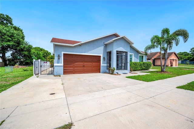 1553 Wright Dr, Lakeland, FL 33805 - view of front of home with stucco siding, an attached garage, driveway, and a gate