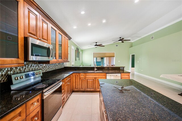 1553 Wright Dr, Lakeland, FL 33805 - kitchen with appliances with stainless steel finishes, crown molding, a sink, vaulted ceiling, and brown cabinetry