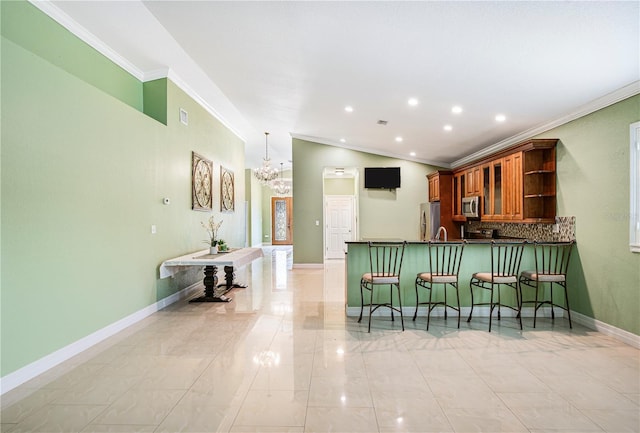 1553 Wright Dr, Lakeland, FL 33805 - kitchen with stainless steel appliances, ornamental molding, a breakfast bar, a chandelier, and a peninsula