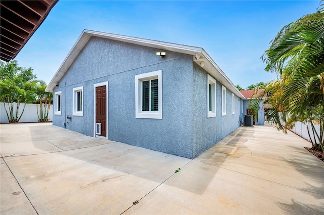 1553 Wright Dr, Lakeland, FL 33805 - view of property exterior with stucco siding, a patio area, a fenced backyard, and central AC unit