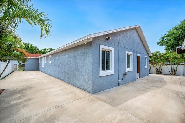 1553 Wright Dr, Lakeland, FL 33805 - view of side of home featuring stucco siding, a patio, and driveway