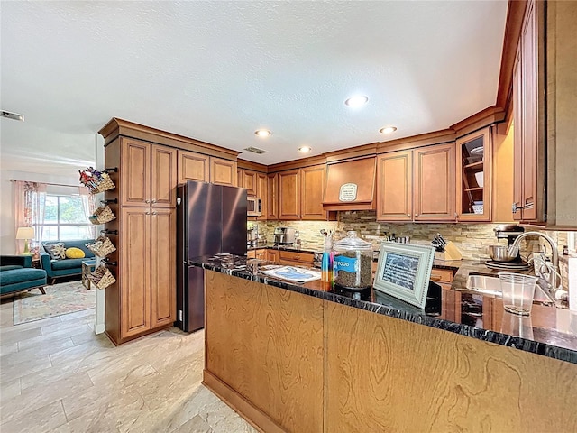 3705 Pine Cir, Lake Wales, FL 33898 - kitchen featuring stainless steel appliances, a sink, backsplash, brown cabinetry, and dark stone counters