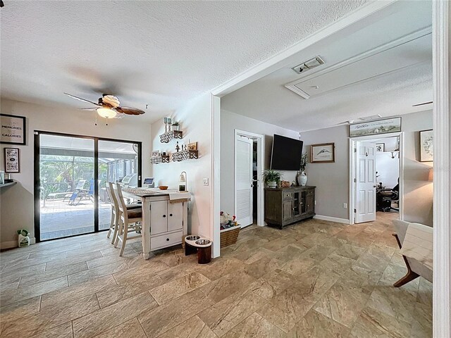 3705 Pine Cir, Lake Wales, FL 33898 - dining room with stone finish floors, a textured ceiling, ceiling fan, and baseboards