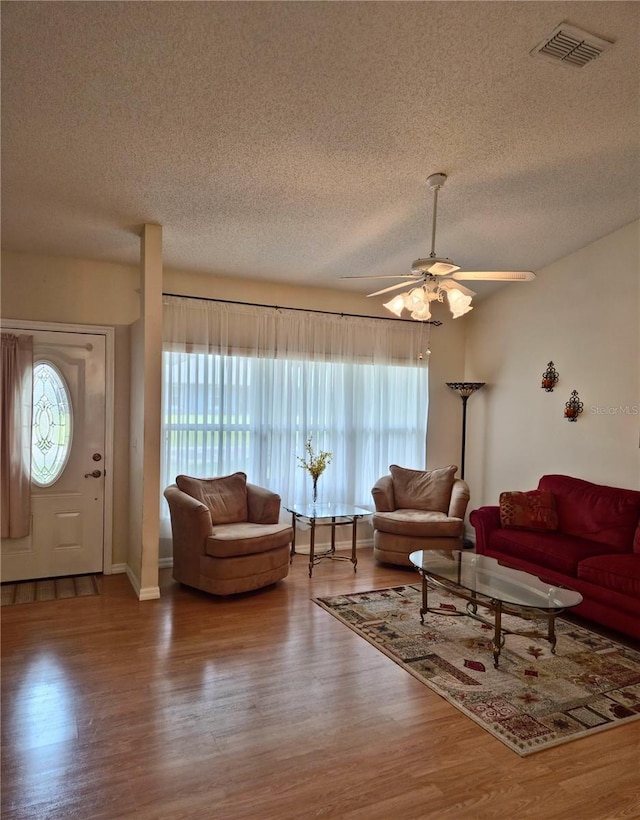 2909 Pine Tree Dr, Edgewater, FL 32141 - living area with wood finished floors, a textured ceiling, a ceiling fan, and baseboards