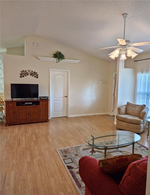 2909 Pine Tree Dr, Edgewater, FL 32141 - living area featuring a ceiling fan, light wood-style flooring, lofted ceiling, baseboards, and a textured ceiling