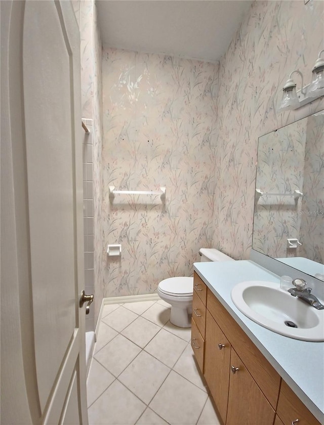 2909 Pine Tree Dr, Edgewater, FL 32141 - bathroom with tile patterned flooring, vanity, toilet, wallpapered walls, and baseboards