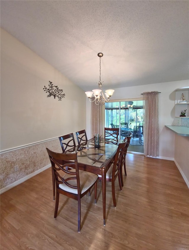 2909 Pine Tree Dr, Edgewater, FL 32141 - dining room with wood finished floors, a chandelier, baseboards, and a textured ceiling