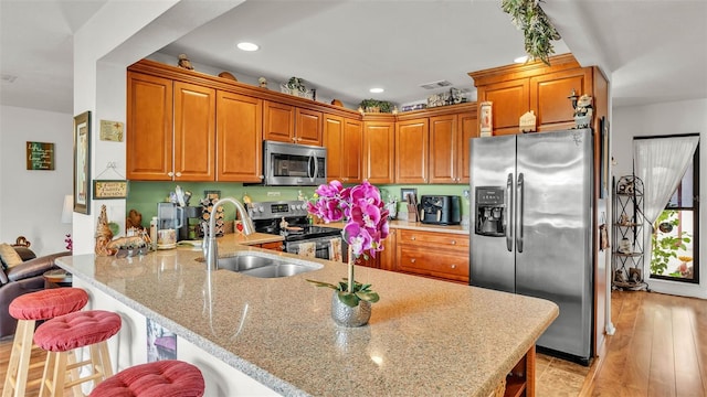 527 Duchess Dr, Lakeland, FL 33803 - kitchen with stainless steel appliances, a sink, a peninsula, light stone countertops, and a breakfast bar area