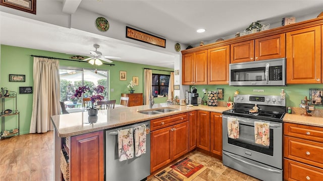527 Duchess Dr, Lakeland, FL 33803 - kitchen with appliances with stainless steel finishes, a peninsula, a sink, brown cabinets, and recessed lighting
