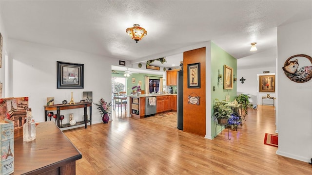 527 Duchess Dr, Lakeland, FL 33803 - living area with a textured ceiling, light wood finished floors, a ceiling fan, and baseboards