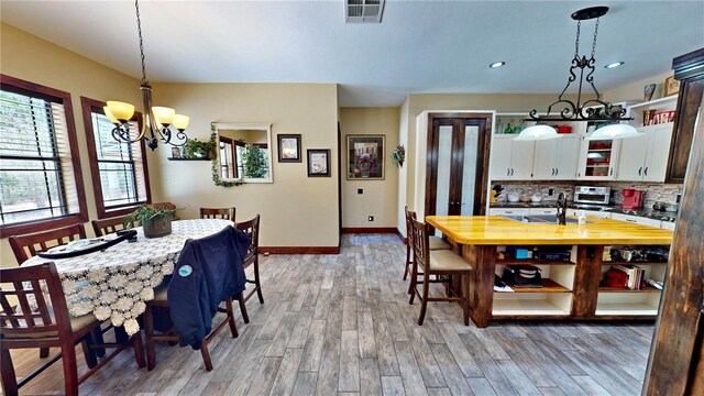 540 Phillips Rd, Sebring, FL 33875 - dining space with a chandelier, baseboards, light wood-type flooring, and recessed lighting