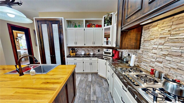 540 Phillips Rd, Sebring, FL 33875 - kitchen featuring a sink, light wood-type flooring, tasteful backsplash, white cabinetry, and butcher block countertops