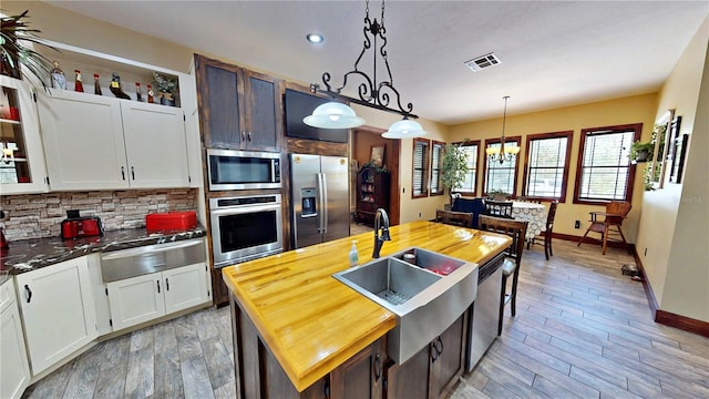 540 Phillips Rd, Sebring, FL 33875 - kitchen with appliances with stainless steel finishes, a warming drawer, butcher block counters, tasteful backsplash, and baseboards
