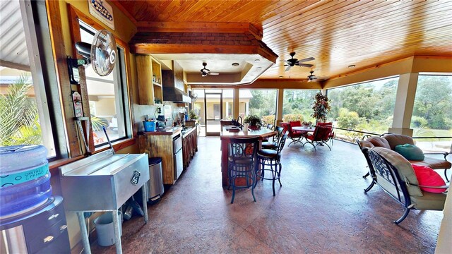540 Phillips Rd, Sebring, FL 33875 - kitchen featuring wooden ceiling, ceiling fan, a breakfast bar, wall chimney range hood, and a kitchen island