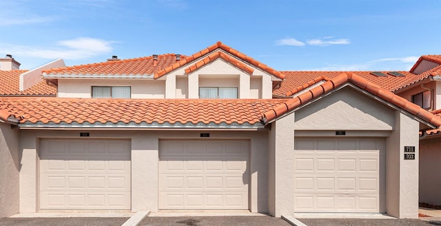 703 Magnolia Pl Unit 703, Winter Haven, FL 33884 - view of front of home featuring community garages, stucco siding, and a tiled roof