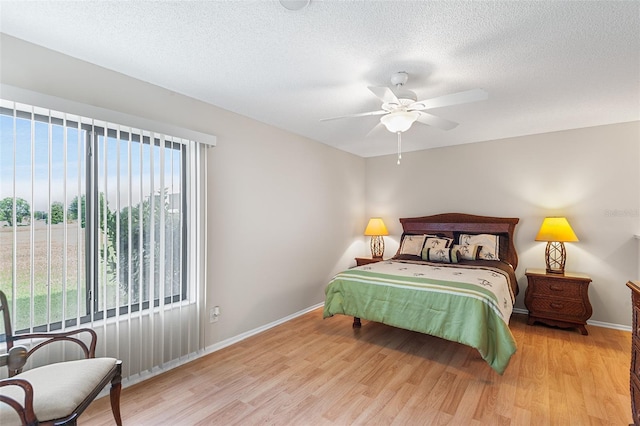 703 Magnolia Pl Unit 703, Winter Haven, FL 33884 - bedroom featuring light wood-style flooring, baseboards, a textured ceiling, and ceiling fan